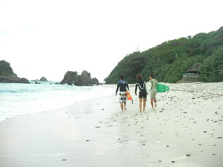 砂浜を歩くサーファー達